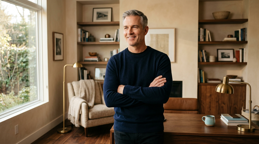 Confident 52-year-old American man with salt-and-pepper hair standing tall in a warm home office — Maynox how to look younger over 50